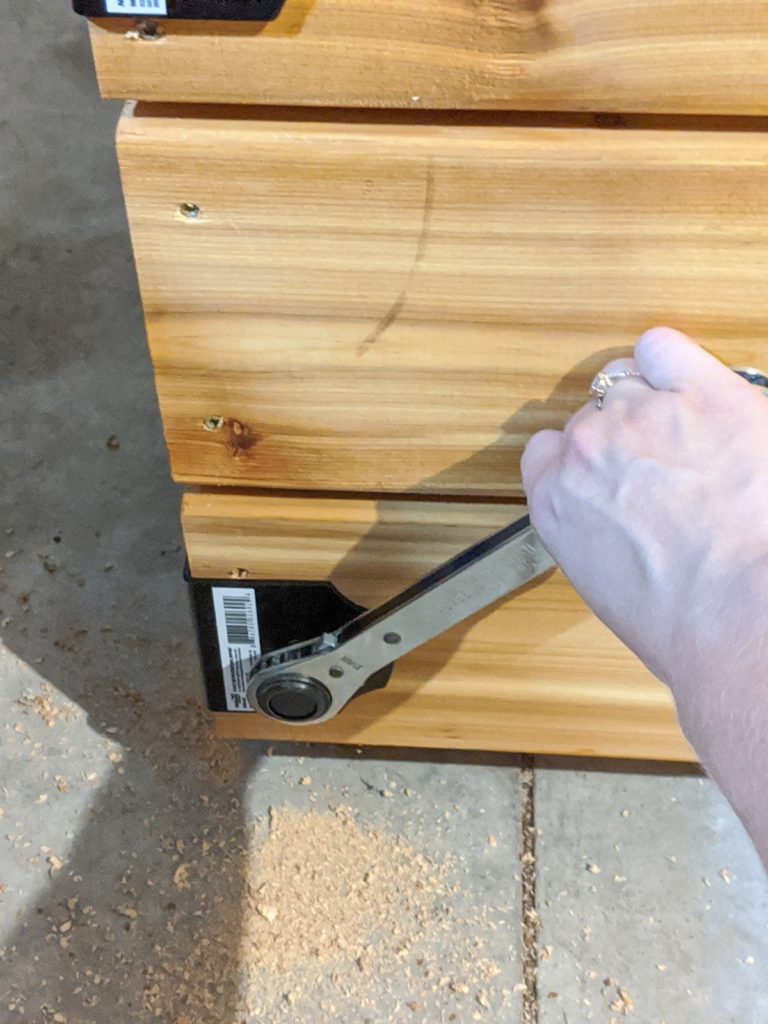 Installing the decorative hardware using a ratcheting wrench to put in the lag screws