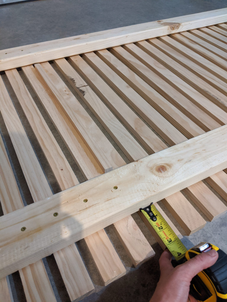 Measuring out the boards before screwing them into one another for the wood slat planter wall