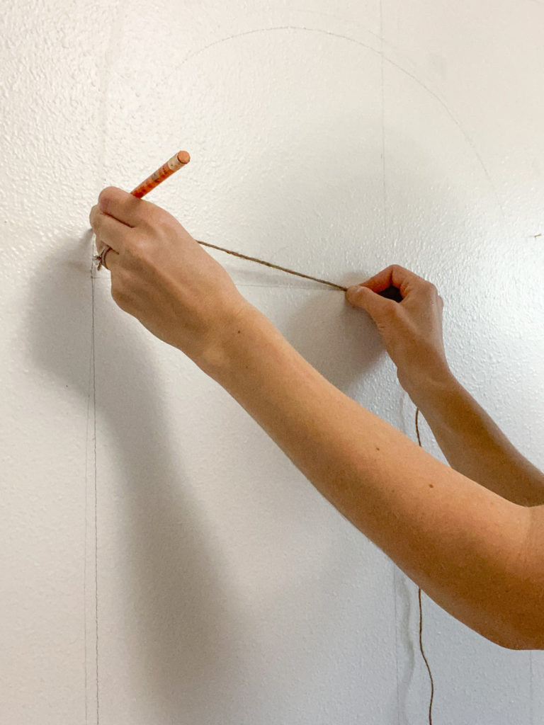 Drawing an arch on the wall using a string and a pencil