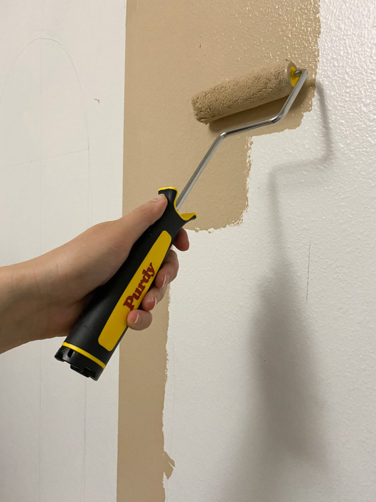 Using a Purdy mini roller to paint the design on the wall
