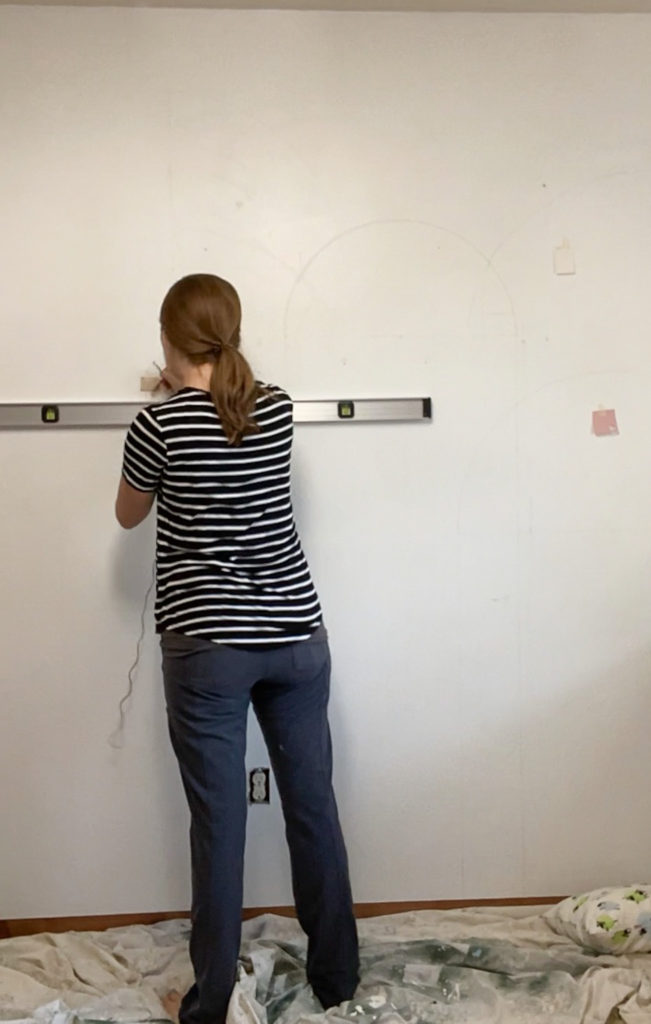 Drawing out the color blocking design on the wall with a level and pencil
