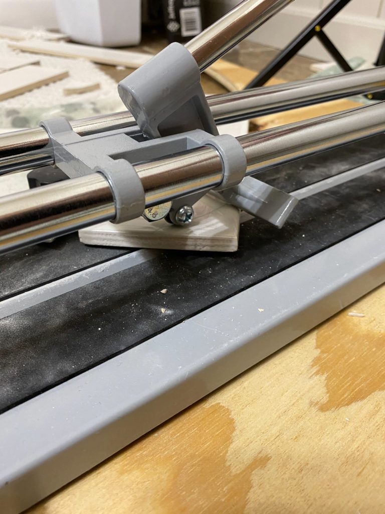 Scoring and snapping tiles with tile cutter for herringbone design