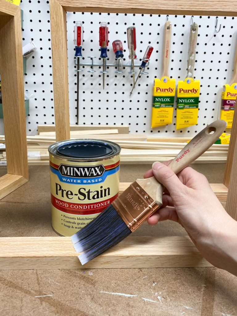 Applying pre-stain wood conditioner to modern wall art frames
