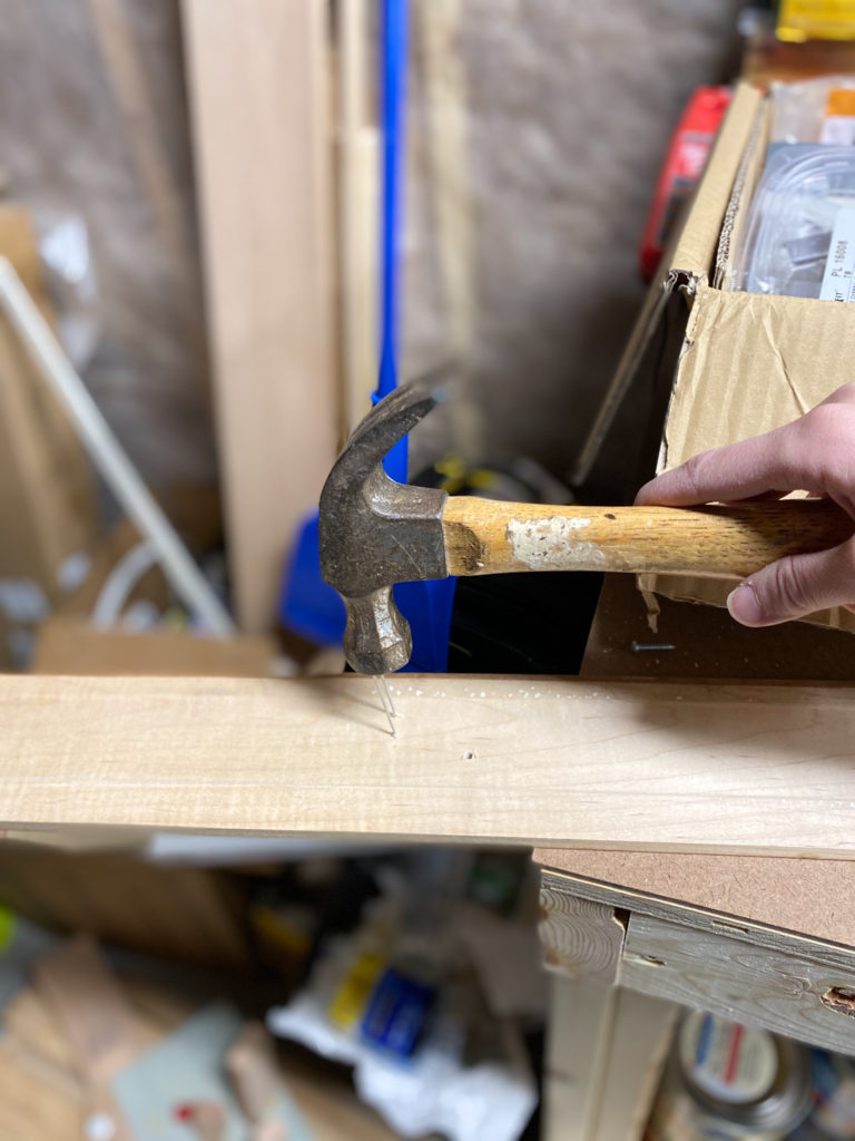 Removing nails from trim with hammer