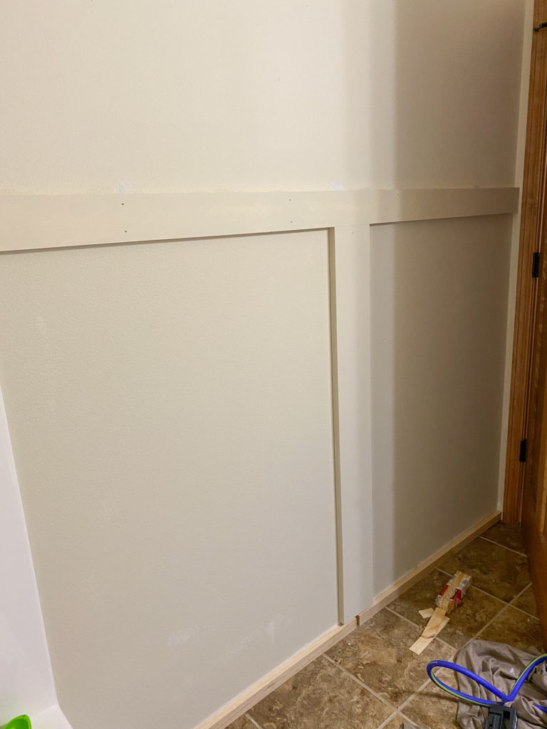 Attaching shiplap to a wall in the bathroom, starting with the middle piece