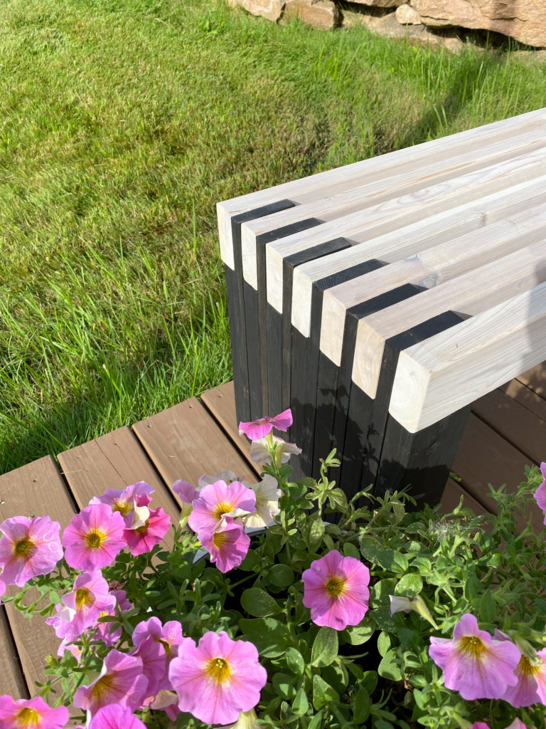Close-up of modern outdoor bench with alternating black and white stain